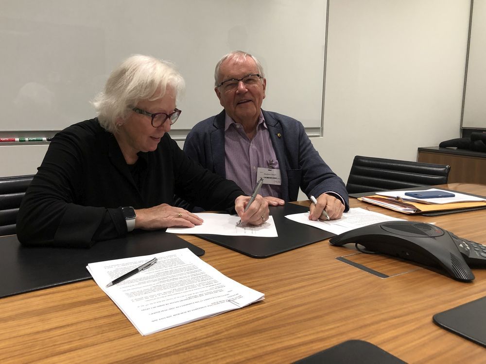 Mountain Galleries founder Wendy Wacko signs a purchase agreement for a collection of artwork from the estate of artist Doris McCarthy in 2019. She is pictured with Steve Smart, the estate art executor. She is donating the work to the Doris McCarthy Gallery at the University of Toronto. 