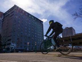 A cyclist rides along 5th Street on a windy day in downtown Calgary on Monday, April 11, 2022.
