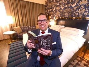 David Keam, general manager of The Dorian Hotel, holds a book by Oscar Wilde in one of the hotel's show suites.