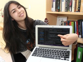 Grade 9 student Rachel Simantov poses for a photo with her MacBook in her southwest Calgary home on April 17, 2022.