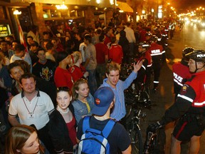 Police hold their perimeter to prevent celebrating Flames fans from spilling into traffic on 17th Avenue SW after the Flames' 3-0 victory over the San Jose Sharks on May 17, 2004.
