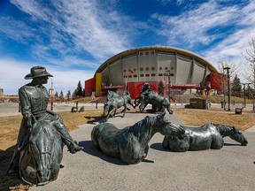 Stampede Park’s By the Banks of the Bow statue frames the Scotiabank Saddledome on Monday, April 4, 2022.