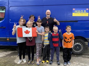 Calgarian Paul Hughes poses recently with refugee children in Ukraine.