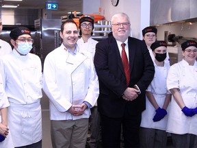 Demetrios Nicolaides, Minister of Advanced Education, and David Ross, SAIT president and CEO, pose with first year baking students following an announcement for new funding for the John Ware Building. April 14, 2022.
