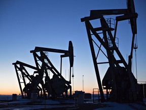 The silhouettes of pumpjacks are seen above oil wells in the Bakken Formation near Dickinson, North Dakota, U.S., on March 7, 2018.