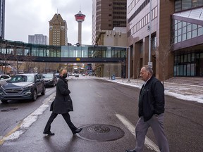 People cross Centre Street on a chilly day in downtown Calgary on Wednesday, April 13, 2022.