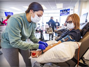 Auxiliary nurse Melissa Robles connects tube to donor Nathalie Drouin-Courtois, who was donating plasma at a Hema-Quebec blood clinic in Kirkland.