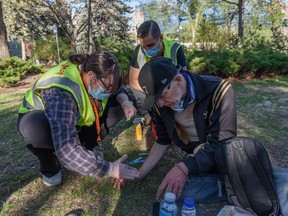 BeTheChangeYYC emergency medical volunteers Olivia Levy and Chaz Smith help treat Dustin McKeeman's frozen hands in downtown Calgary on May 25, 2022. McKeeman said his hands were frozen after he was prevented from boarding a CTrain station to shelter during a cold snap.  last winter