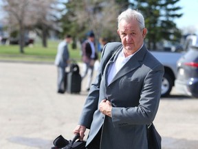 Flames head coach Darryl Sutter arrives as the team departs Calgary en route to Dallas on May 6, 2022, during their first-round playoff series with the Stars.