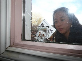 Crizelle-Ann Sanico blickt am Mittwoch, den 11. Mai 2022, auf ein Einschussloch in der Frontscheibe des Hauses ihrer Familie im Block 1100 der 36 St SE in Calgary. Sie lebt nicht im Haus, aber Familienmitglieder waren am späten Dienstag zu Hause Nachts, als eine Kugel das Fenster durchschlug, ein Stuhl von einer Wand abprallte und schließlich in einem Türrahmen stecken blieb.