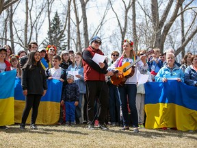 Guests at a BBQ picnic for Ukrainians fleeing war take part in a flash mob singing of the Ukrainian military anthem at Bowness Park in Calgary on Sunday, May 1, 2022.