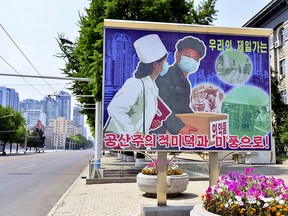 A COVID-19 public health sign is displayed beside an empty thoroughfare in Pyongyang, North Korea, on May 23, 2022.