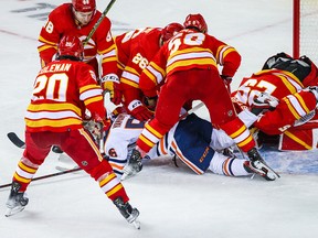 Edmonton Oilers right wing Kailer Yamamoto (56) and Calgary Flames goaltender Jacob Markstrom (25) collide during the third period in game one of the second round of the 2022 Stanley Cup Playoffs at Scotiabank Saddledome on May 18, 2022.