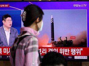 A woman watches a TV broadcasting a news report on North Korea's launch of three missiles including one thought to be an intercontinental ballistic missile (ICBM), in Seoul, South Korea, May 25, 2022.