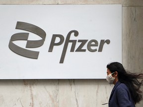 A woman walks past a Pfizer logo in the Manhattan borough of New York City on April 1, 2021.