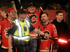 Police monitor crowds as Flames fans celebrate on the Red Mile after the Calgary Flames defeated the Dallas Stars in Game 1.