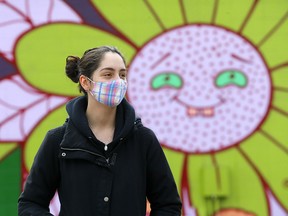 Katrina Nabozniak stands in front of a cheerful mural on the side of Hotel Arts in Calgary on April 25, 2021.