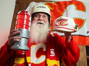 Calgary Flames super fan Kim Thomas has been a long- time supporter of the team. Thomas wears one of Hakan  Loob's helmets from the 1989 Stanley Cup winning team and holds a signed 1989 Calgary Flames Stanley Cup championship cap in his home on Monday, May 16, 2022. 
Gavin Young/Postmedia