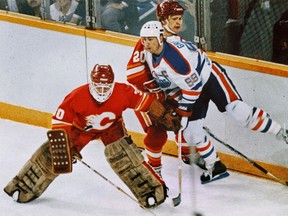 Edmonton Oilers forward Wayne Gretzky gets hit by Calgary Flames defenceman Gary Suter and goalie Mike Vernon during their 1986 playoff series.