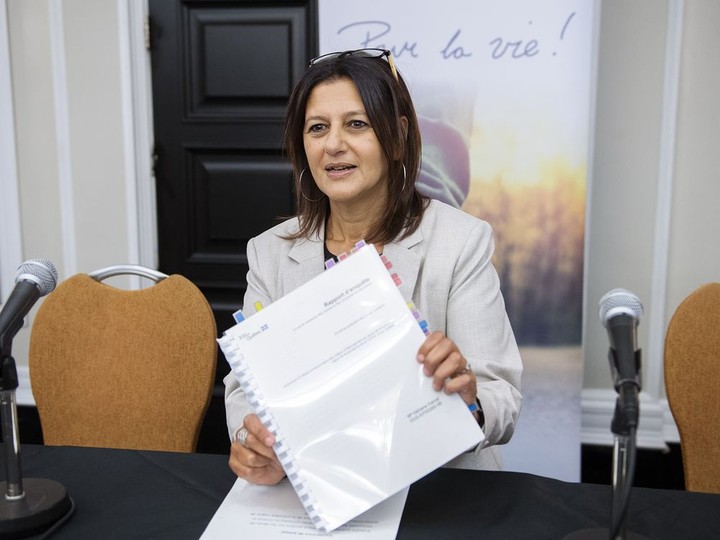  Quebec coroner Géhane Kamel holds up a copy of her report into the deaths of residents in Quebec’s long-term care homes at the beginning of the COVID-19 pandemic, prior to a news conference in Montreal, Thursday, May 19, 2022.