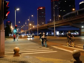 Cyclists wearing masks are shown on a nearly deserted street in central Beijing on May 12.