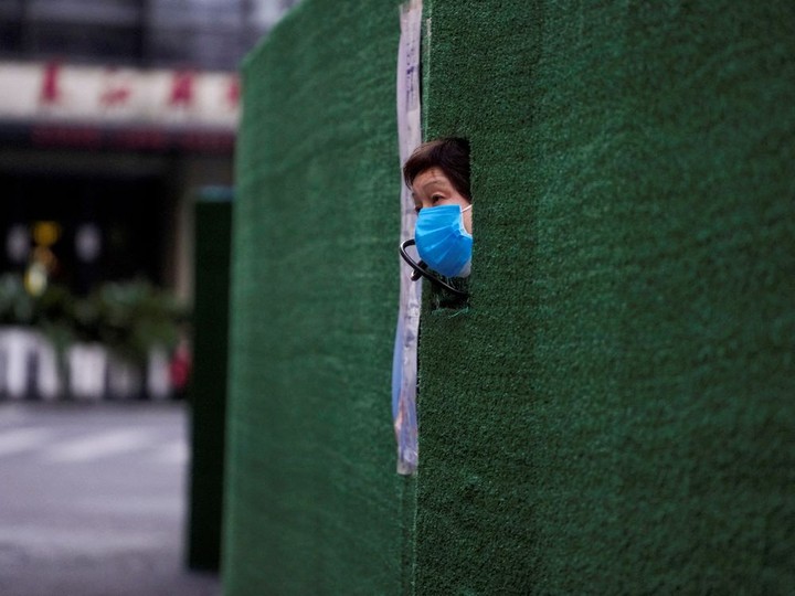  FILE PHOTO: A resident looks out through a gap in the barrier at a residential area during lockdown, amid the coronavirus disease (COVID-19) pandemic, in Shanghai, China, May 6, 2022. REUTERS/Aly Song/File Photo