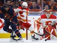 Calgary Flames defenceman Oliver Kylington, centre, checks Edmonton Oilers winger Evander Kane as goalie Jacob Markstrom follows the puck during Game 3 of their second-round playoff series at Rogers Place in Edmonton on Sunday, May 22, 2022.