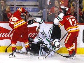 Flames forwards Matthew Tkachuk and Johnny Gaudreau battle for the puck against the Dallas Stars in Calgary on April 21.