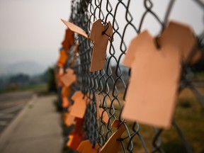 Cutouts of orange t-shirts are hung on a fence outside the former Kamloops Indian Residential School, in Kamloops, B.C., on Thursday, July 15, 2021. The B.C. First Nation whose discovery of unmarked graves on the grounds of a former residential school sparked a national reckoning over Canada's treatment of Indigenous Peoples says it's planning a new search.