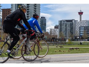 Now is the time to chart a new, sustainable course for greater downtown Calgary, reinventing the core to be a place that delivers a high quality of life for all citizen at a much lower rate of consumption, say the authors. Pictured, cyclists on the Riverwalk pathway in East Village earlier this year.  Azin Ghaffari/Postmedia
