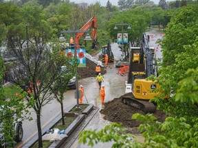 City crews build a berm across Memorial Drive N.W. by the Bow River pathway to protect Sunnyside against potential flooding on Tuesday.