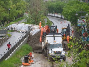 City crews build a berm across Memorial Drive N.W. by the Bow River pathway to protect Sunnyside against potential flooding on Tuesday.