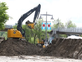City of Calgary crews work near Memorial Dr. and 3 St. W on removing part of a berm constructed to stop rising waters from the Bow River in the community of Sunnyside on June 16, 2022.