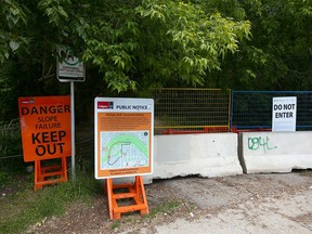 Signs warning residents and pathway users of possible dangers at the base of McHugh Bluff on 3 Ave NW in Calgary on Wednesday, June 22, 2022.