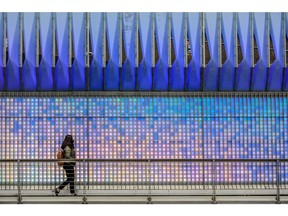 A pedestrian walks past the light panels along the renovated underpass on 4th Street SW in Calgary.  Gavin Young/Postmedia
