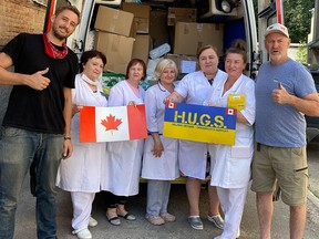 Paul Hughes (R) with fellow volunteers and medical staff while delivering supplies.