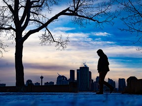 FILE PHOTO: A man walks in moody light in Calgary on Friday, December 3, 2021.