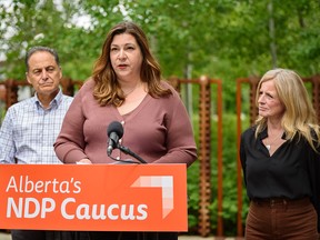 Paula Hall speaks about her difficulty getting emergency surgery for her teenaged daughter at a press conference in Calgary on Thursday. She is flanked by Calgary MLA Joe Ceci and NDP Leader Rachel Notley.