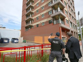 Calgary police and ASIRT team commander Gary Creasser investigate the scene at Riverfront Avenue and 1st Street S.E. where a woman fell off a balcony on June 19, 2019.