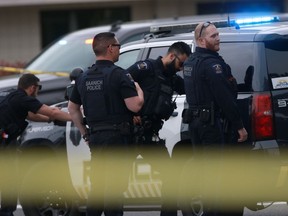 Saanich Police joined by Victoria Police and RCMP respond to gunfire involving multiple people and injuries at a bank in Saanich, B.C., on Tuesday, June 28, 2022. The chief of police in Saanich says it is truly amazing that no members of the public were hurt during a gunfight at a bank in which two robbery suspects died.