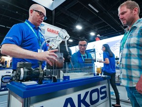 Ross McGowan demonstrates a scale model at the John Brooks Company booth at the Global Energy Show in Calgary on Tuesday, June 7, 2022.