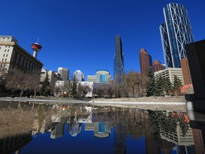 The downtown Calgary skyline is reflected in a pool of water at Olympic Plaza on Monday, April 26, 2021. Calgary city council heard form some of its wholly-owned subsidiaries such as Calgary Economic Development on their 2021 numbers.