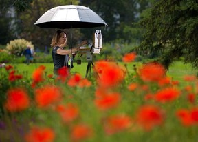 Calgary artist Larisa Nikonova paints the poppies in Riley Park.  Gavin Young/Post Media