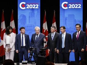 Candidates, left to right, Leslyn Lewis, Roman Baber, Jean Charest, Scott Aitchison, Patrick Brown, and Pierre Poilievre pose on stage following the Conservative Party of Canada English leadership debate in Edmonton, on Wednesday, May 11, 2022.