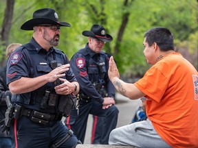 Cst. Brad Milne speaks with a group in Olympic Plaza in downtown. There’s no full-fledged police station in Calgary’s core after the service closed its Victoria Park location in 2017.