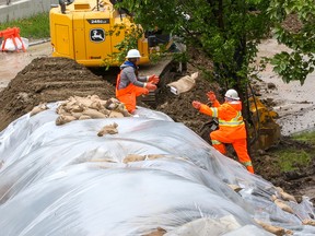 City of Calgary crews strengthen a berm with sandbags on Memorial Drive on Tuesday, June 14, 2022.