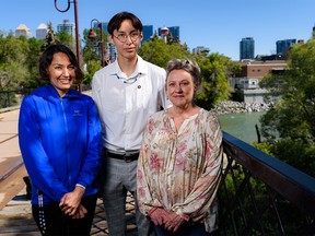 Keegan Buffalo, a grade 12 student from Tsuut'ina Nation who attends Saint Mary's High School, poses for a photo with his mother Billie-Dee Buffalo, left, and teacher Michelle Hayden on a bridge over the Elbow River on Tuesday, July 5, 2022.