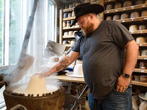 Cody Harrison blocks a hat.  Harrison, who has been working at Smithbilt Hats for five years, made about 3,500 hats last year.