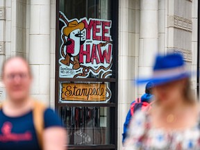 People walk past a Stampede window painting on Stephen Avenue in downtown Calgary.