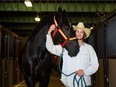 Chance Bell poses for a photo with Fancy Toes at the draft horse barn on the Stampede grounds on Friday, July 8, 2022.